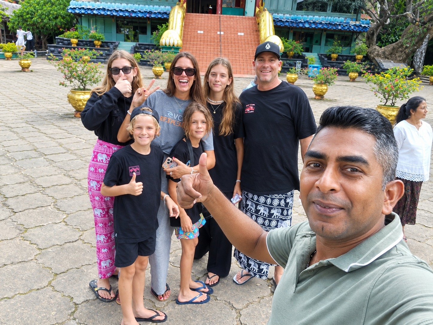 Family tour group thumbs up at a historic Buddhist temple