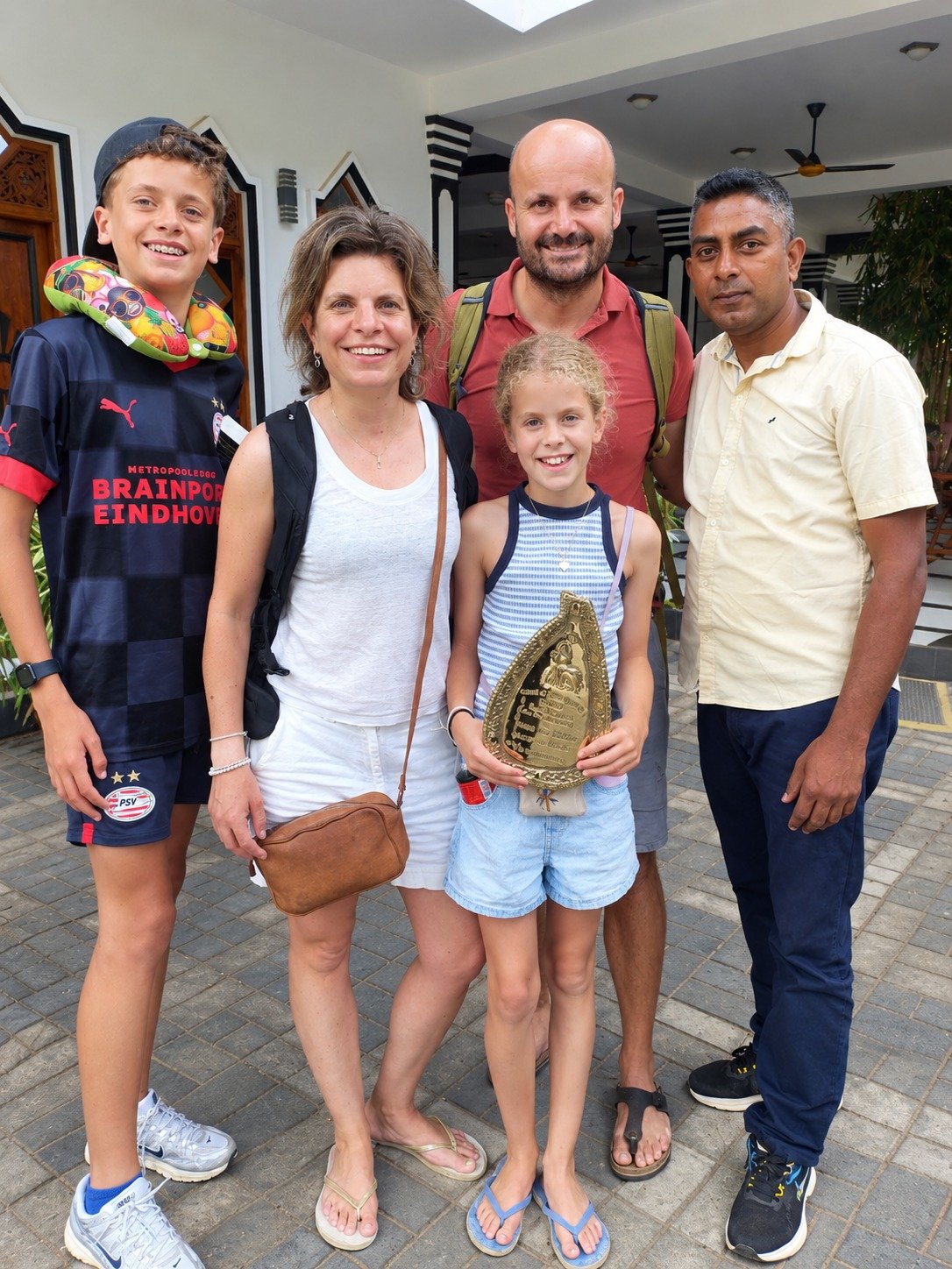 Family receiving traditional Sri Lankan brass souvenir with their JK Tours chauffeur